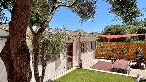 A backyard with a lawn, a wooden fence, and outdoor furniture.
