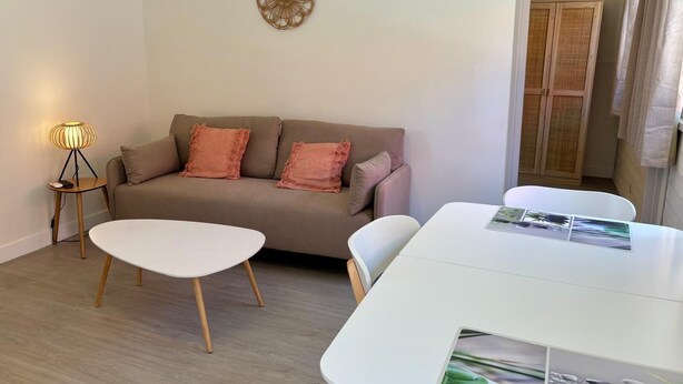 A modern living room with a sofa, a coffee table, a lamp, and a clock on the wall.