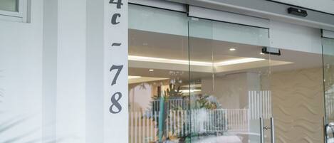 Un edificio moderno con una puerta de cristal y el número '4c-78' en la pared.