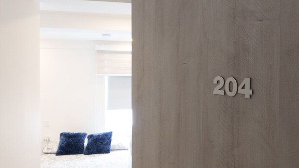 A room with a wooden wall and a number '204' indicating the room number. - RECOVERY HOUSE BY ZENYA HOST (Cali)