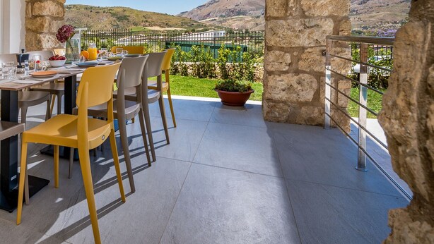 A dining area with a table set for four, surrounded by stone walls and a view of the countryside. - Villa Aglea – Private Oasis with Pool Relax & Comfort in Castellammare del Golfo (CASTELLAMMARE DEL GOLFO)