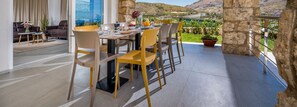 A dining area with a table set for four, surrounded by stone walls and a view of the countryside.