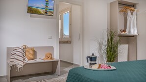 A modern bedroom with a bed, a bench, a coffee machine, and a view of the beach through an open door. - Villa Aglea – Private Oasis with Pool Relax & Comfort in Castellammare del Golfo (CASTELLAMMARE DEL GOLFO)