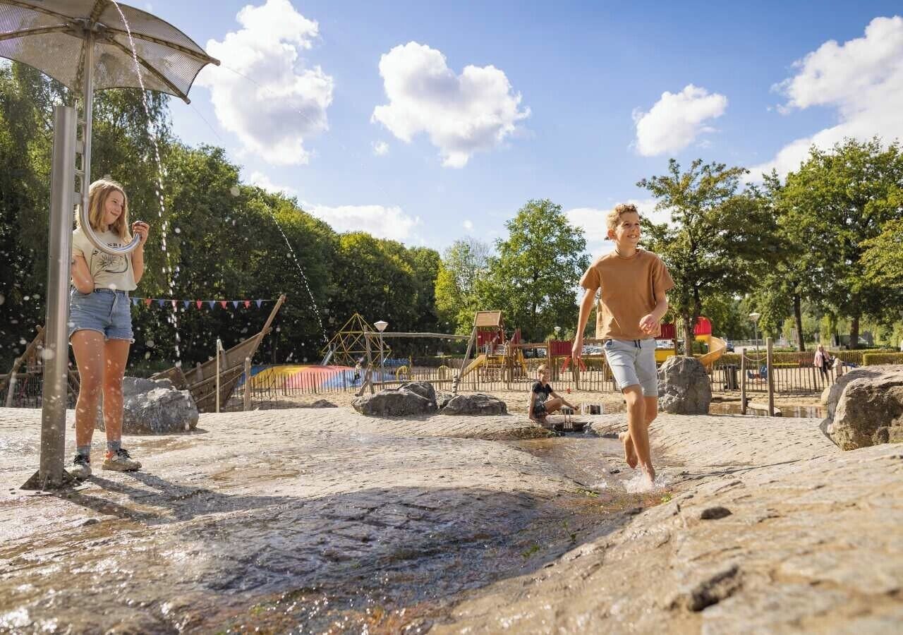 Une personne marchant sur un terrain rocheux, avec un élément aquatique en arrière-plan.