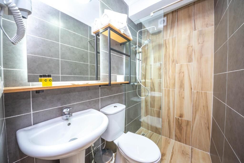 A bathroom with a sink, toilet, and shower.