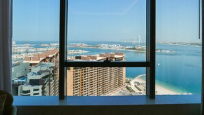 A high-rise building with a view of a coastal cityscape, including a prominent bridge and a beach. - Bird S-eye View Studio Palmtower (Dubai)