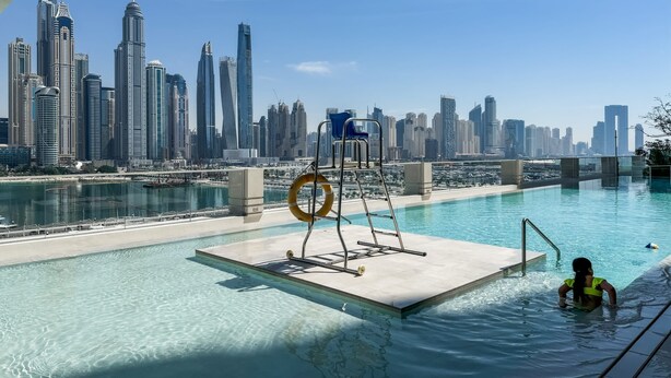 Una piscina con vista sullo skyline della città, un galleggiante e una scala.