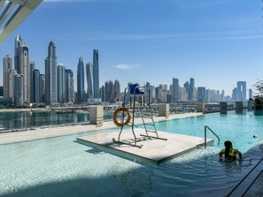 Ein Pool mit Blick auf eine Stadtlandschaft, einem Rettungsring und einer Leiter.