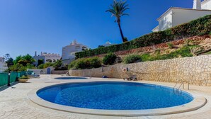 A swimming pool with a stone wall and lounge chairs. - Azula Bright and Airy 2 Bedroom Apartment With p (Lagoa)
