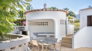 A patio with a table and chairs, surrounded by a white wall with decorative tiles and a small tower-like structure. - Carosim Quiet Location Close to Beach Private (Lagoa)