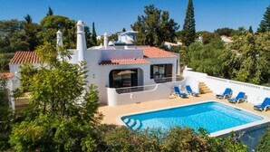 A villa with a swimming pool, a terrace with lounge chairs, and a view of the surrounding greenery. - Carosim Quiet Location Close to Beach Private (Lagoa)