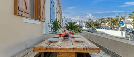 Mesa de madera preparada para comer con vista a la ciudad.