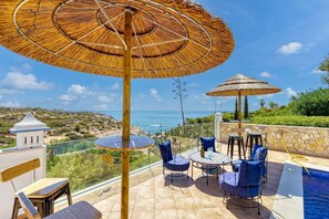 A terrace with outdoor seating, a pool, and a view of the ocean. - Casa Beatriz Magnificent Villa Just a few Steps (Lagoa)
