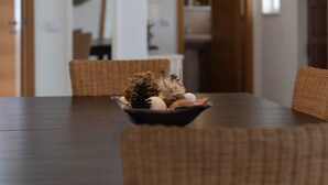 A dining area with a dark wooden table, wicker chairs, and a bowl of decorative items. - 16 Centeanes Fabulous Location Just Short Walk t (Lagoa)