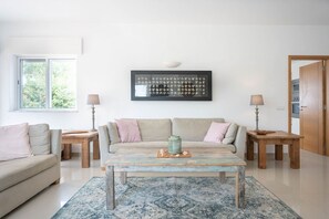 Relax in this stylish living room with a sofa, side tables, and a coffee table.