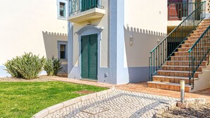 A two-story building with a balcony, a staircase, and a door. - 61B Gramacho Apartment IN THE Heart OF Gramacho (Lagoa)