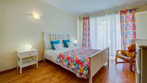 A bedroom with a bed, bedside tables, a chair, and curtains. - 6a Fabrica Velha Beautiful House Pool Walking (Lagoa)