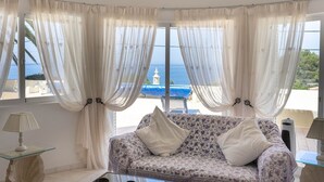 A room with a sofa and a view of the sea. - Silver Beautiful 4 Bedroom Vila Just Steps TO TH (Lagoa)