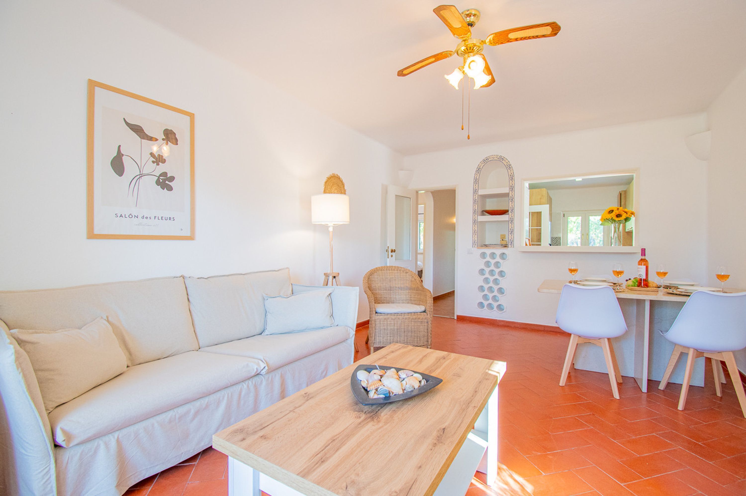 A modern living room with a sofa, a wooden coffee table, and a dining area with chairs and a table.