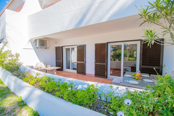Una villa moderna con patio coperto, area salotto esterna e piscina.