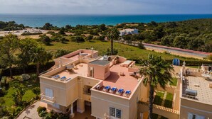 A coastal property with multiple buildings, a view of the sea, and a well-maintained garden. - 11 Marinha Two Bedroom Apt at Praia do Marinha (Lagoa)