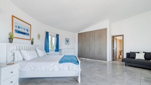 Un'ampia camera da letto con un letto grande, un divano e un armadio.