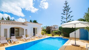 A swimming pool with lounge chairs, a patio area, and a building with a tiled roof. - La Pausa in Carvoeiro (Lagoa)