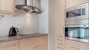 Een moderne keuken met roestvrijstalen apparatuur, houten kastjes en een granieten werkblad.