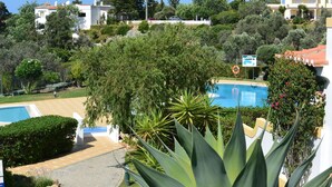 A pool area with a lifeguard sign, surrounded by lush greenery and a clear sky. - 54 Golf mar Carvoeiro Apartment With Fabul (Lagoa)