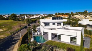 A modern two-story house with a swimming pool, solar panels, and a view of the surrounding neighborhood. - Casa Blanca Magnificent 4 Bedroom Villa With MOD (Lagoa)