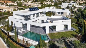 A modern two-story house with a swimming pool, solar panels, and a well-maintained garden. - Casa Blanca Magnificent 4 Bedroom Villa With MOD (Lagoa)