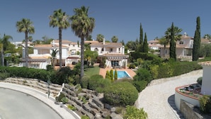 Uma área residencial com várias casas, uma piscina e jardins bem cuidados.