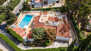 Vista aérea de una propiedad con piscina, varias terrazas y jardines exuberantes.
