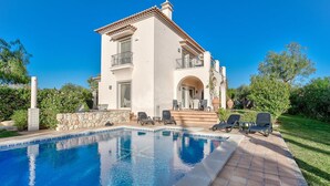 A two-story building with a swimming pool, outdoor seating, and a stone wall. - Casa Marta Three Bedroom Villa With sea Views (Lagoa)