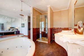 A modern bathroom with a large bathtub, a separate shower area, and a vanity with a mirror. - Casa Ninho Spacious 5 Bedroom Villa in an Enviab (Lagoa)