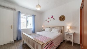 A bedroom with a bed, bedside tables, a window with curtains, and wall decorations. - C22 Quinta do Paraiso Superbly Appointed AND FUR (Lagoa)