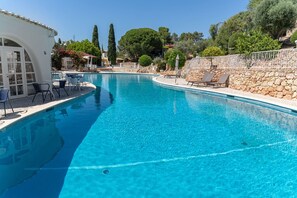 A clear blue pool with lounge chairs and a stone wall. - C22 Quinta do Paraiso Superbly Appointed AND FUR (Lagoa)