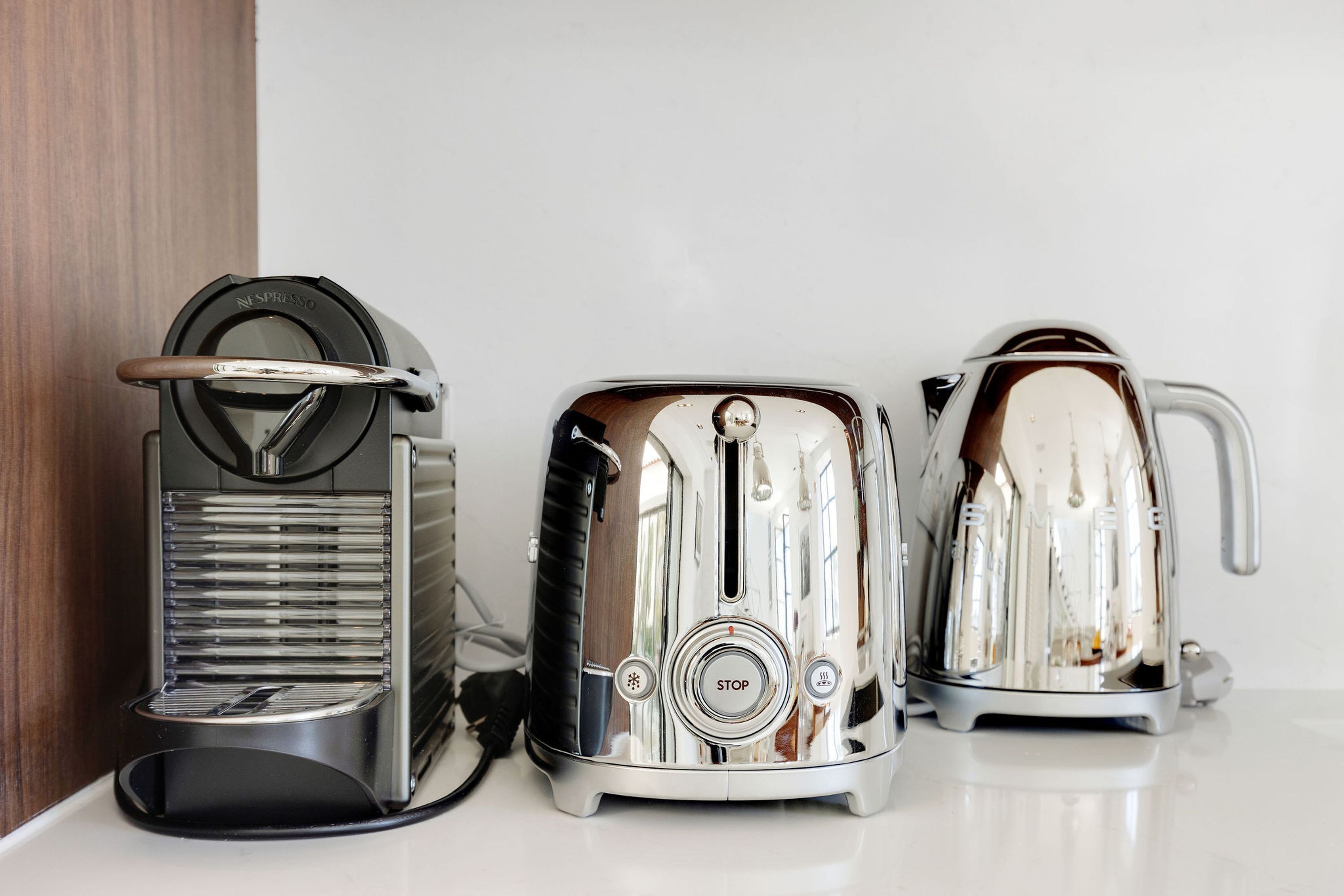 Three kitchen appliances: a coffee maker, a toaster, and a kettle.