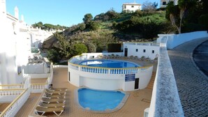 A rooftop swimming pool with a circular design, surrounded by lounge chairs and a small pool area. - 135 Monte Dourado Two Bed Apartment With Communa (Lagoa)