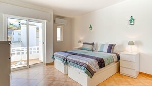 A bedroom with a bed, bedside tables, a sliding glass door, and a balcony. - Elizabet Modern Apartment in the Heart of the Ci (Lagoa)