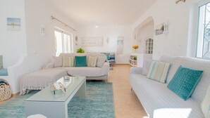 A spacious living area with a sofa, a coffee table, and a dining table. - 61 vdm Superb Villa on Vale do Milho With Heated (Lagoa)