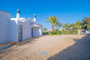 A white building with a tiled roof, a wooden door, and a gravel driveway. - 61 vdm Superb Villa on Vale do Milho With Heated (Lagoa)