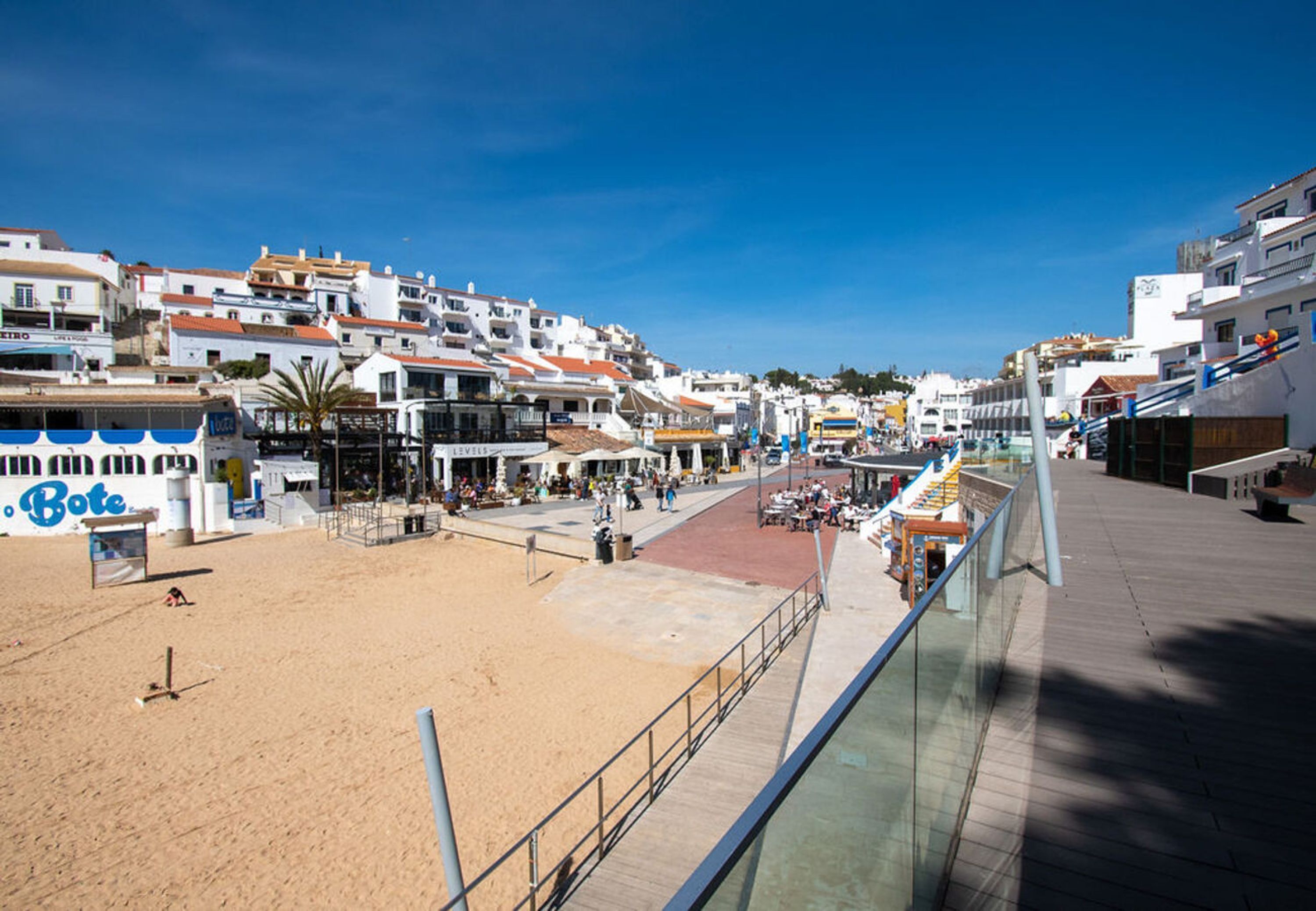 Eine Küstenstadt mit Sandstrand, einer Uferpromenade und Gebäuden mit Balkonen.