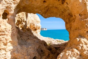 A natural rock formation with a cave entrance. - C65 Quinta do Paraiso (Lagoa)
