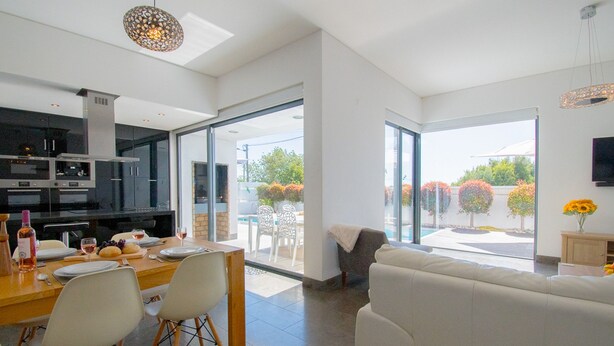 Una cocina moderna con comedor, ventanas amplias y vistas al exterior.