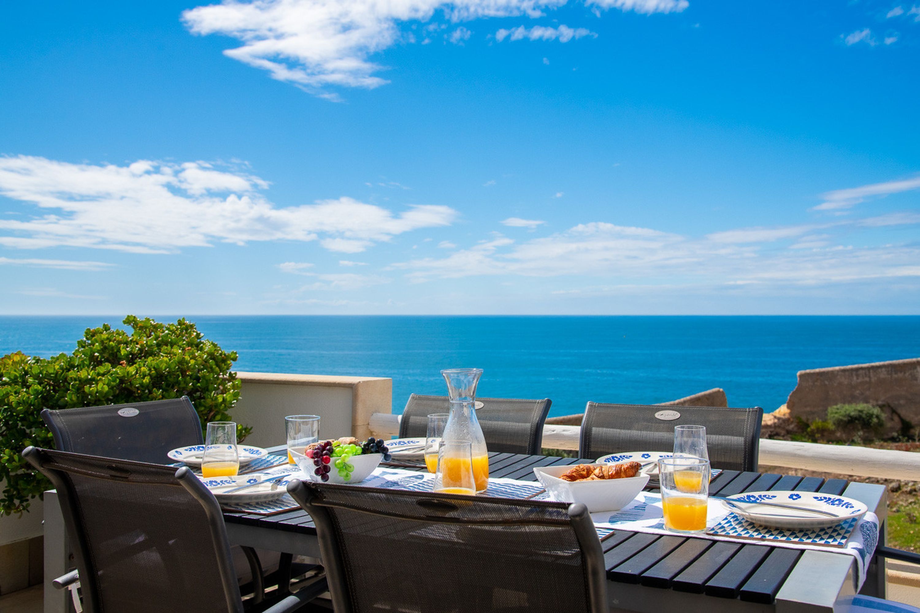 A table set for breakfast with a view of the ocean.
