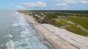 A coastal property with a beach, a large house, and surrounding greenery. - Paradise Found | Ocean & Marsh Views (Edisto Island)
