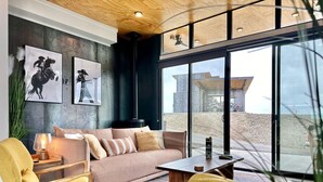 A modern living room with a sofa, chairs, a coffee table, and artwork on the wall. - Cactus & Cabernet~Tesla Charger~Hot Tub~Waffle Bar (Quincy)