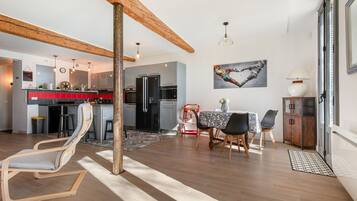 Eine moderne Küche mit roter Spritzschutzwand, ein Essbereich mit Tisch und Stühlen sowie ein Holzboden.