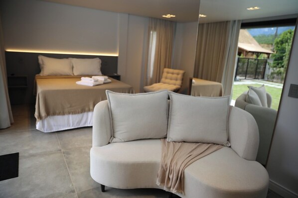 A modern hotel room with a bed, a sofa, and a chair. - Zenith Pousada e Bistro (Praia Grande)